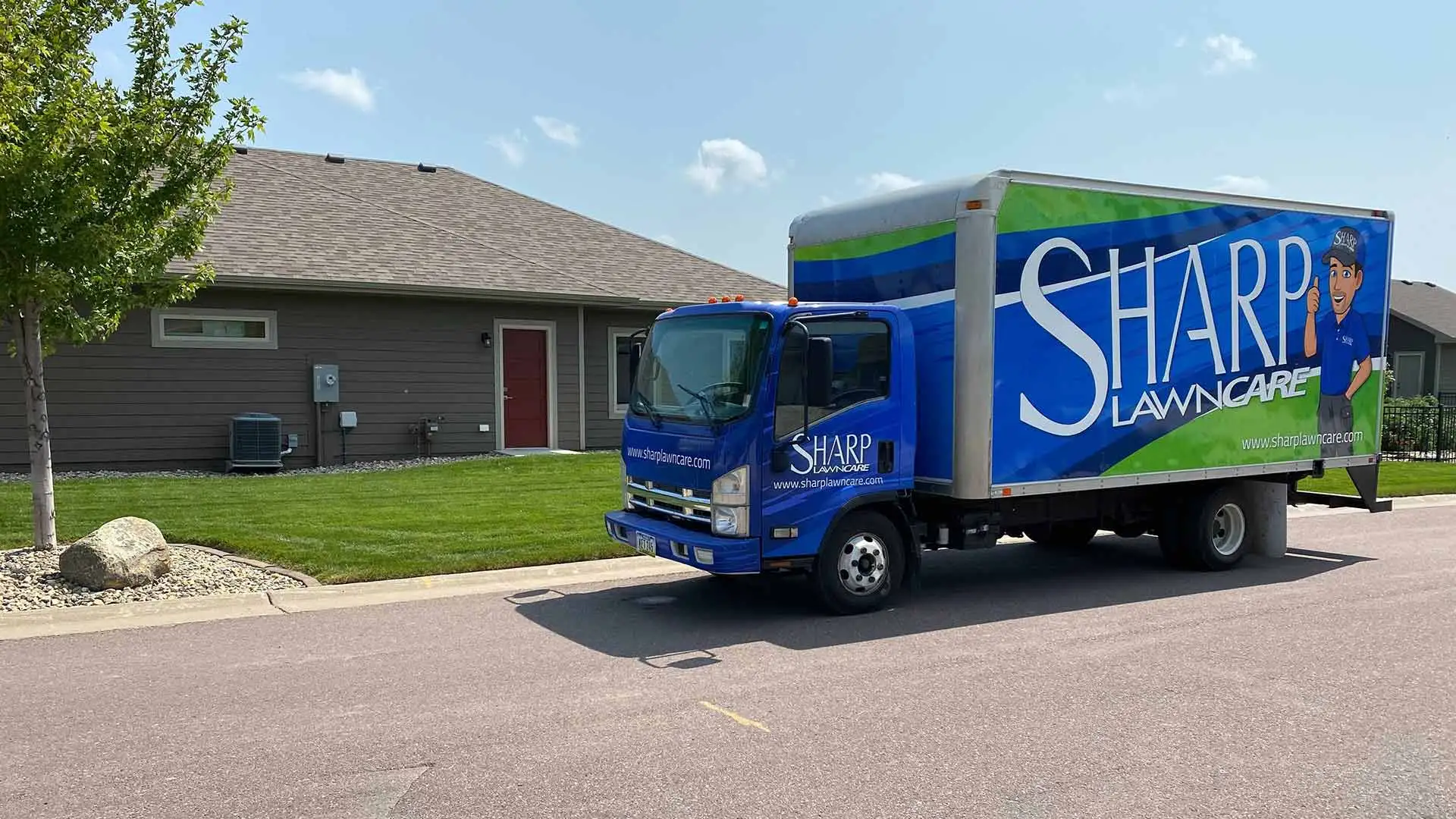 Sharp Lawn Care service truck at a property in Sioux City, IA.