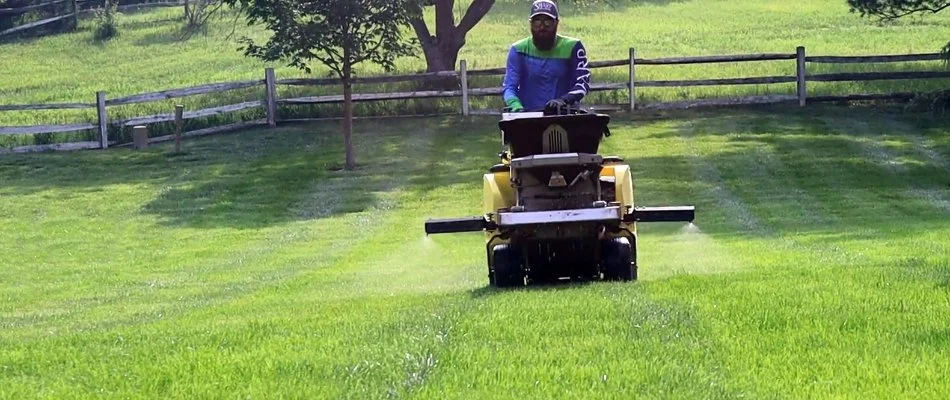 Worker in Sioux Falls, IA, fertilizing lawn. 