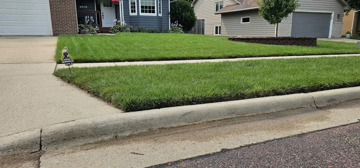 Healthy weed-free front lawn at a Sioux Falls home maintained by Sharp Lawn Care