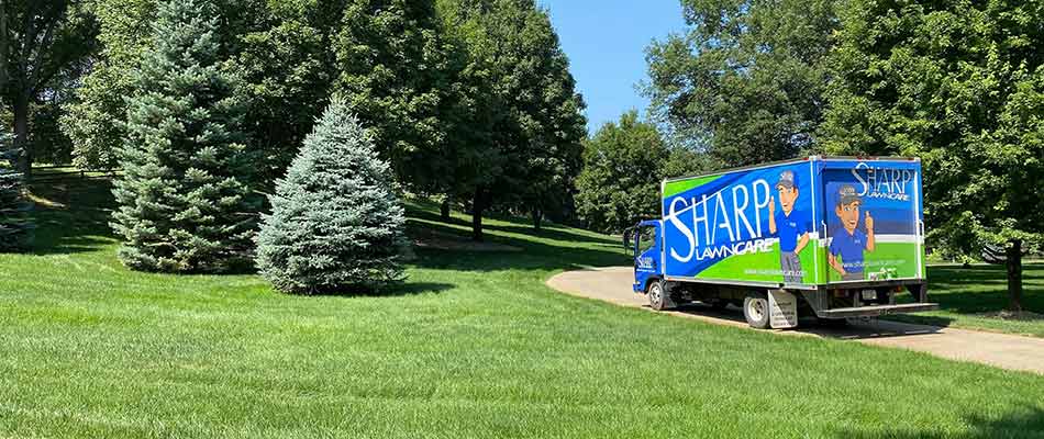Sharp Lawn Care work truck by a large yard near Sioux City, IA.