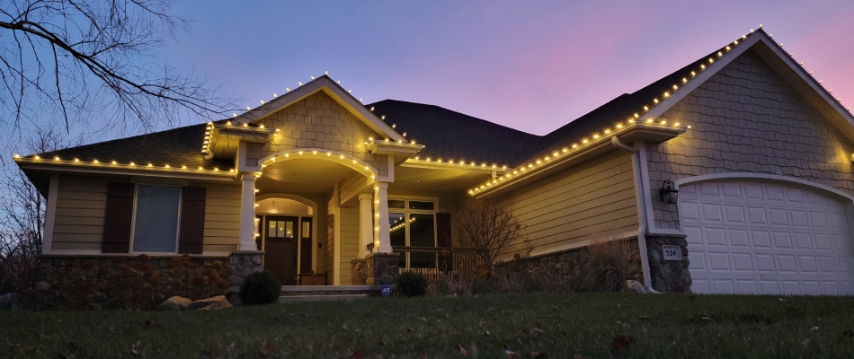 White holiday lighting installed on perimeter of a roof in Sioux City, IA.