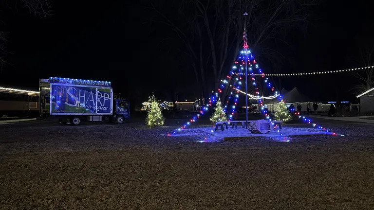 The Sharp box truck parked beside a lit commercial holiday display at night
