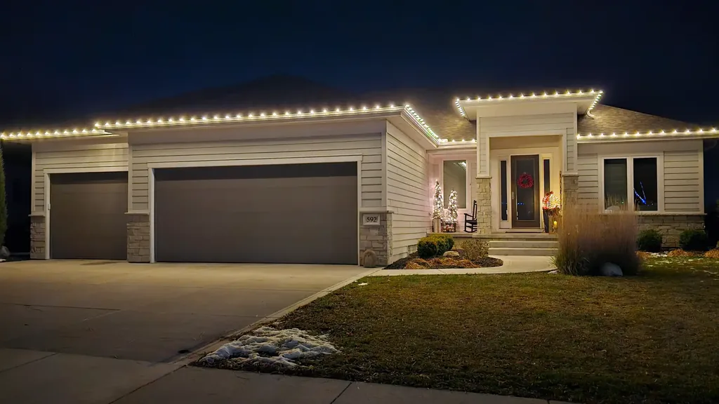 Christmas lights on the eaves, both gables and the entry of a house in the Sioux City area at night