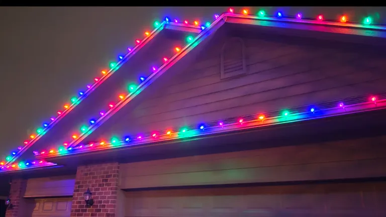 Red, green, blue, orange and purple bulbs alternating along every gable and eave of a home at night