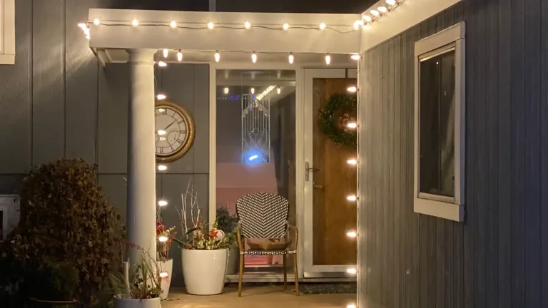 A front porch in the Sioux City area with string lights running across the porch edge and around the entry
