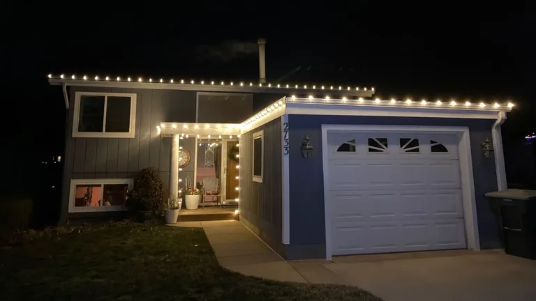 A Sioux City area home at night with Christmas lights carried along the roofline, the peaks and the entry