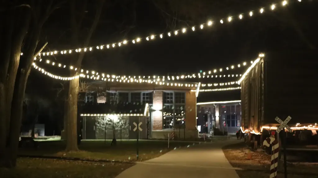 String lights carried from the trees across to the museum buildings above the walkway at the Sioux City Railroad Museum