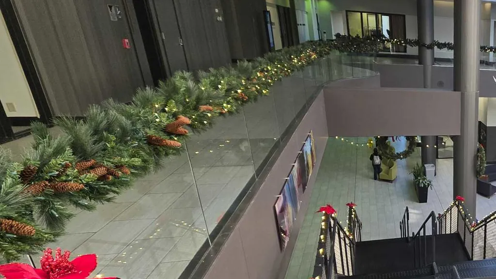 Lit garland with pine cones along an interior balcony railing above the atrium of a downtown Sioux City building