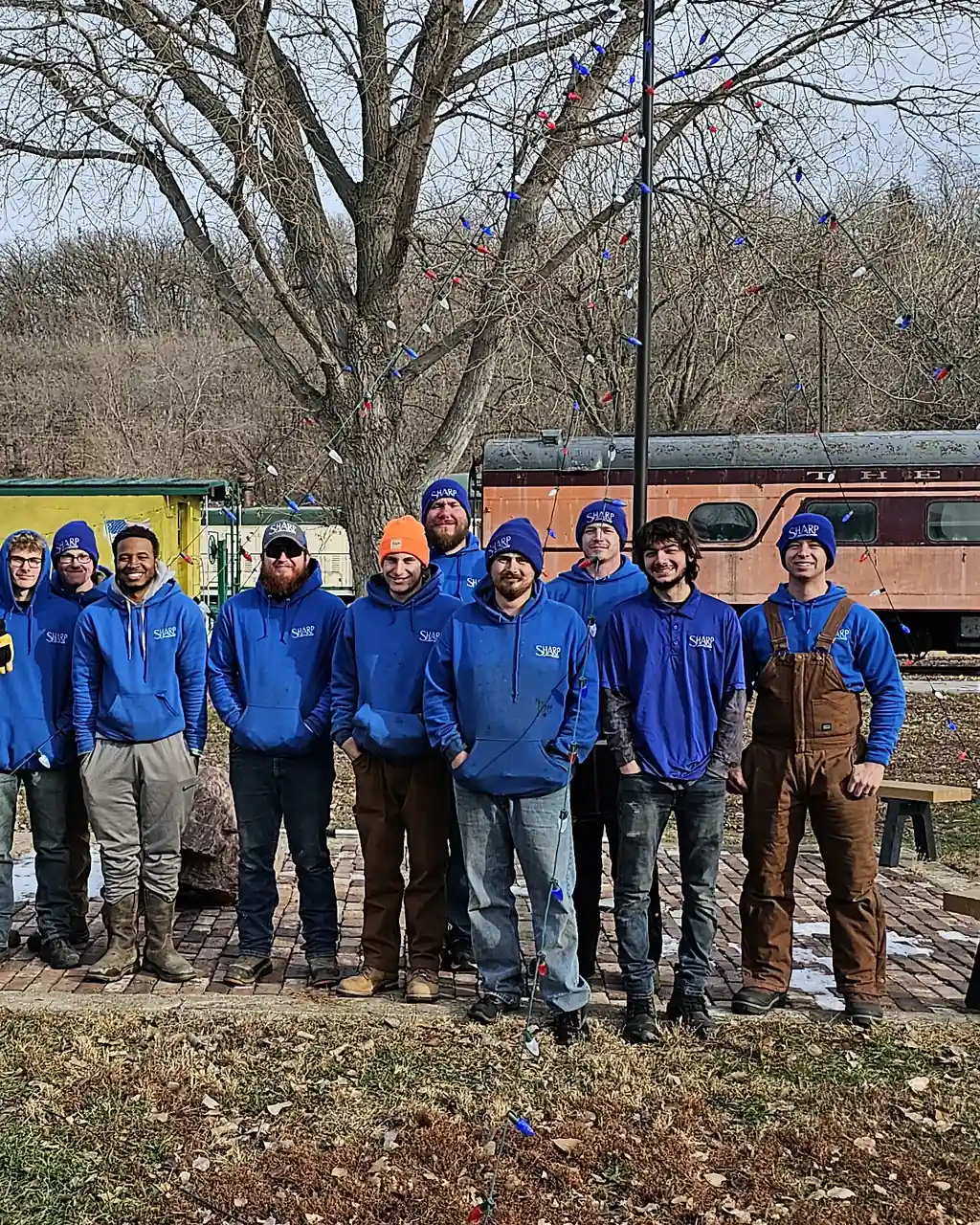 The Sharp Lawn Care Sioux City crew in Sharp blue, framed close