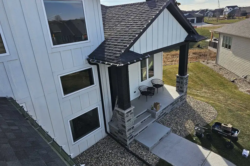 Looking straight down from the roof of a Sioux Falls home over a lit entry porch