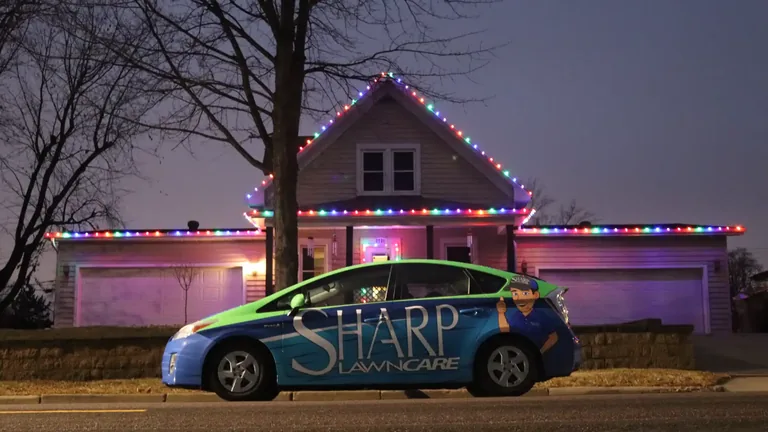 The Sharp Lawn Care car in the driveway of a Sioux Falls home after a Christmas light installation